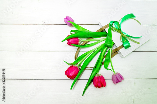 Bunch of red and purple tulips on white wooden background with copy space like postcard on womens day