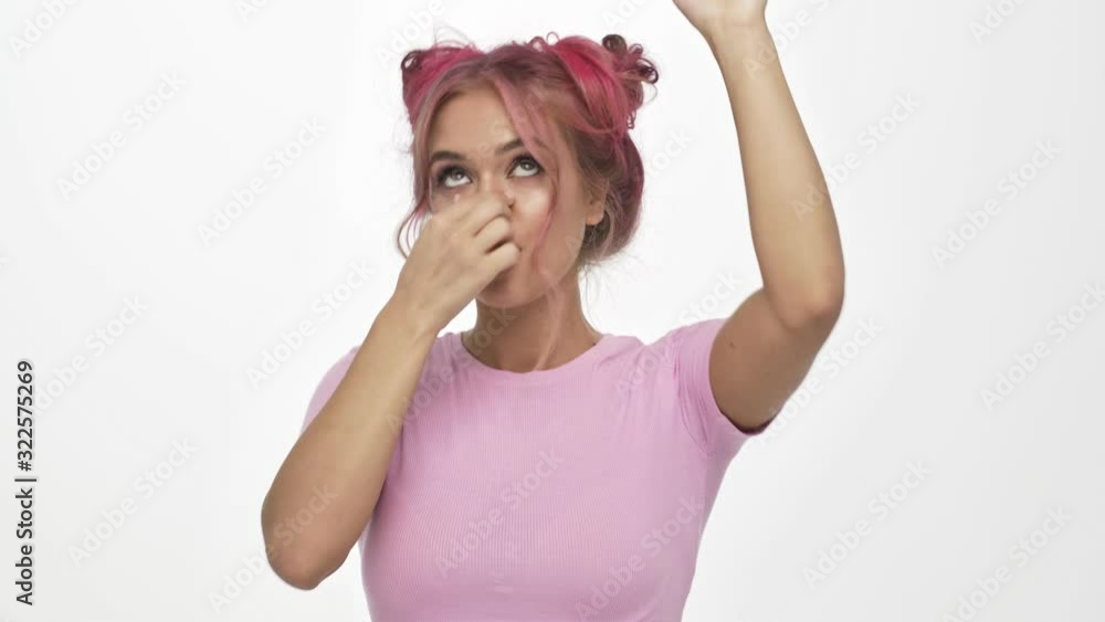 A stylish pretty young woman with the colored pink hairstyle is dancing isolated over white background A stylish pretty young woman with the colored pink hairstyle is dancing isolated over white background