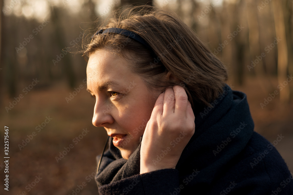 Woman adjusts headphones in ears