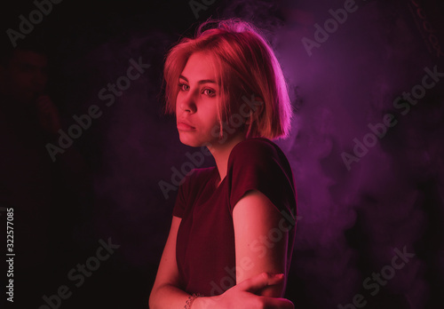 portrait of an impulsive girl with a Bob haircut in neon red and purple light