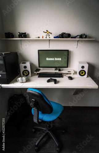 The workplace of a professional gamer with a monitor, gamepad, headphones and an armchair.