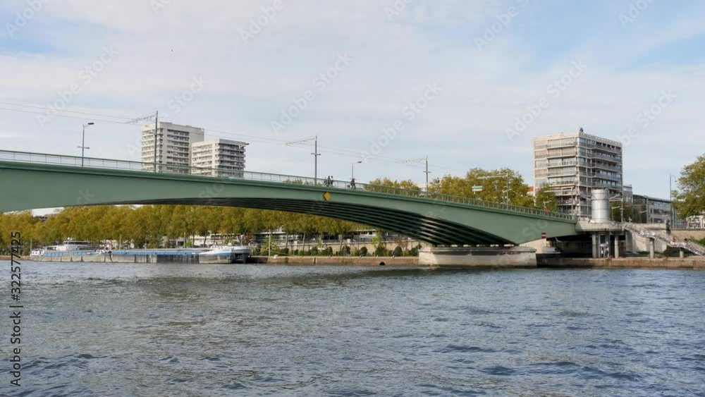 Trams go over the bridge and people are walking. Filmed in Rouen, Normandy, France. The river is the seine. Daylight. Time lapse.