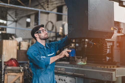Young engineers are doing practical on the job training on how to use a controller for a factory by computer.