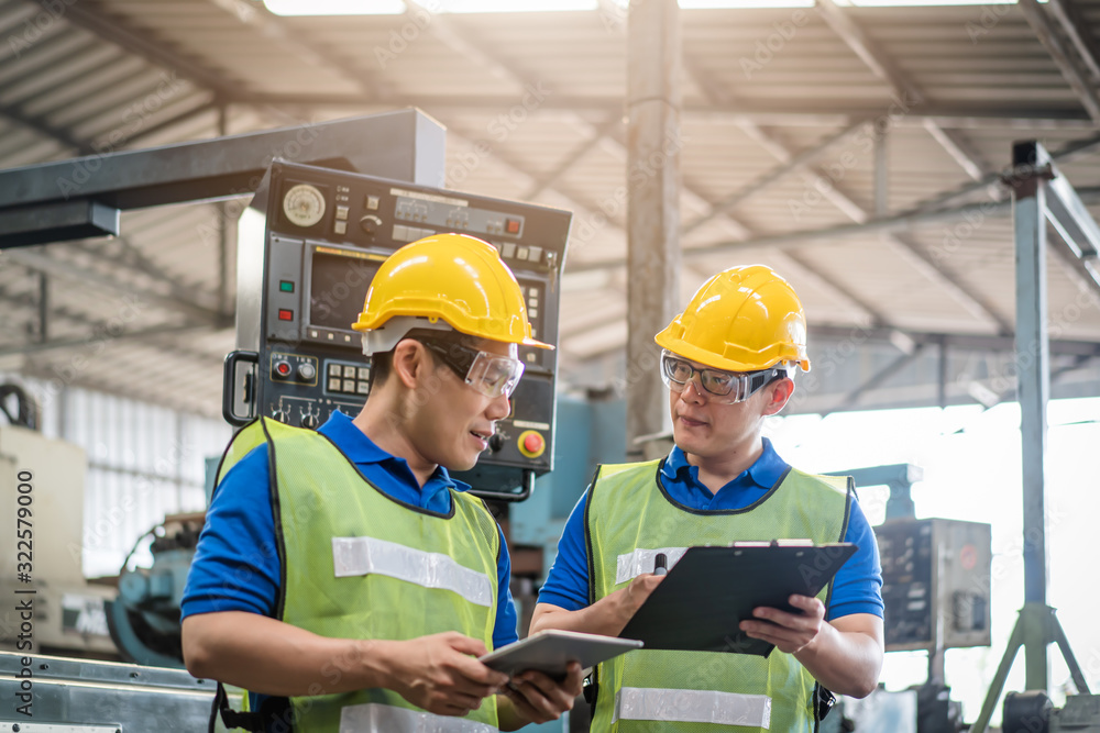custom made wallpaper toronto digitalIndustrial engineers in safety uniforms wearing yellow safety helmets are inspecting work by tools. and on the job training he works in industrial machinery.