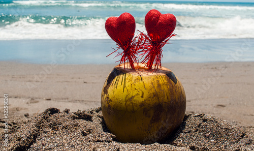 Two red hearts in a coconut on a beach background. valentines day concept