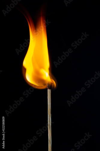 Flame on the matchstick over dark background