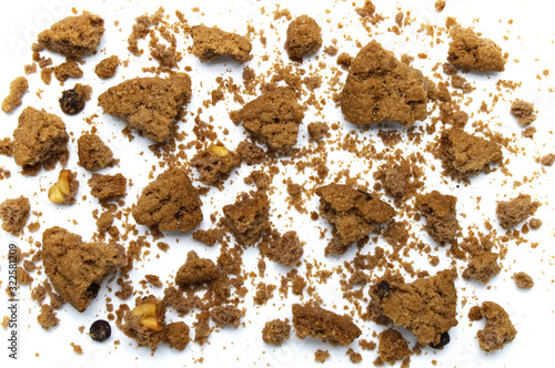 Scattered crumbs of chocolate chip cookies on white background.