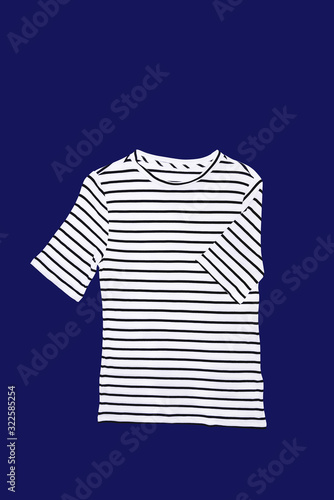 Short-sleeved shirt with white and black stripes on a blue background, isolated.