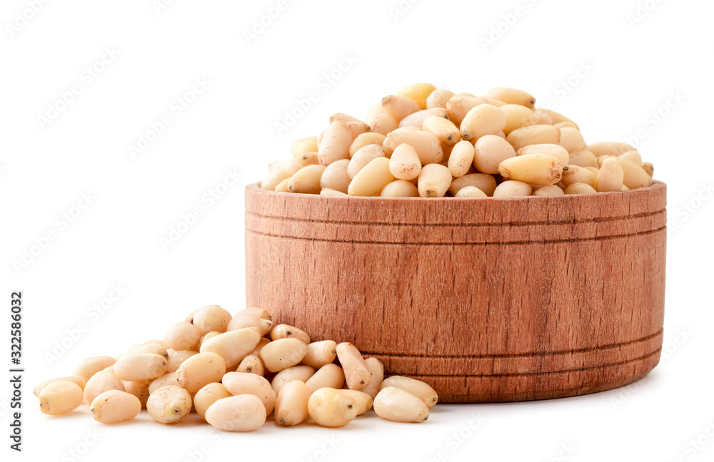 Pine nuts in a wooden bowl close-up on a white. Isolated Pine nuts in a wooden bowl close-up on a white. Isolated