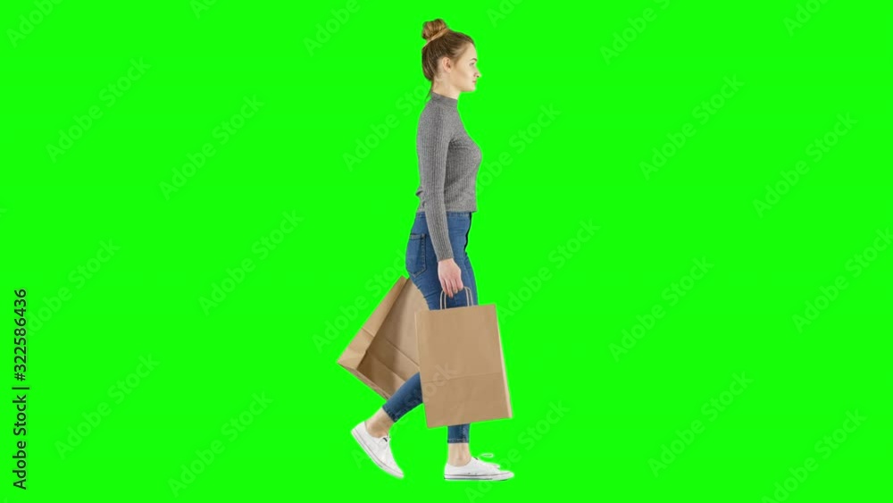 Young Woman Walking Back From Shopping Holding Paper Bags on Green Screen Young Woman Walking Back From Shopping Holding Paper Bags on Green Screen
