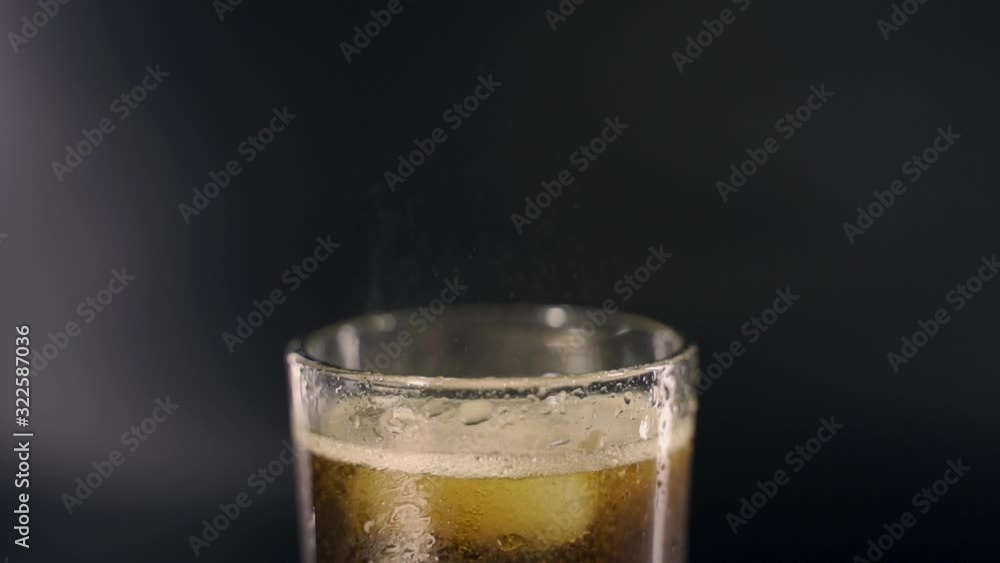Cold cola with ice in a tall transparent glass Cold cola with ice in a tall transparent glass