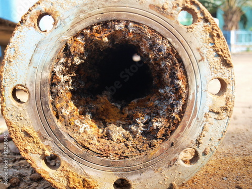 Valokuva Closeup of waste in old water pipes Clogged debris and corroded rust in old plumbing pipes on the cement courtyard background