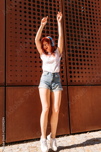 Young girl dancing on street and jumping high up photo