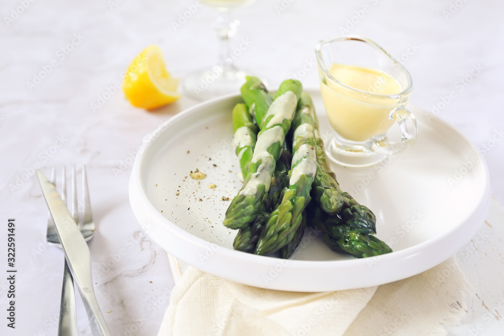 French cuisine. Fresh green asparagus with hollandaise sauce and glass of white wine French cuisine. Fresh green asparagus with hollandaise sauce and glass of white wine