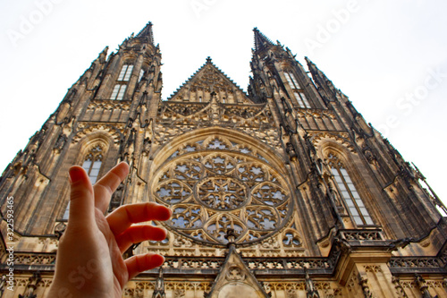 Prague. 05.10.2019: Perspective view of the Metropolitan Cathedral of Saints Vitus, Wenceslaus and Adalbert, an excellent example of Gothic architecture. Golden Gate South Tower with clock. photo