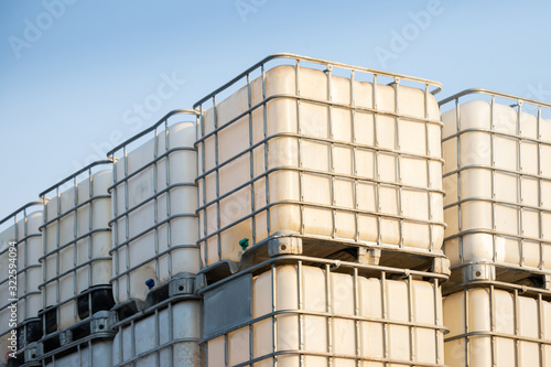 white ibc container in outdoor stock yard of factory, white plastic chemical tanks. photo