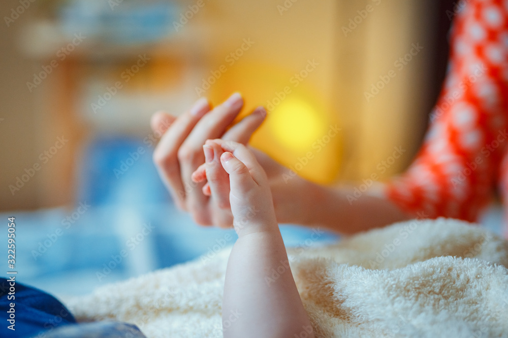 Close-up of baby's hand holding mother's hand. - obrazy, fototapety, plakaty 