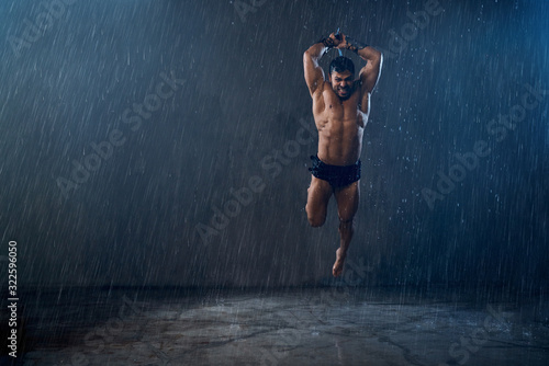 Fototapeta Naklejka Na Ścianę i Meble -  Wet shirtless gladiator jumping in attack.