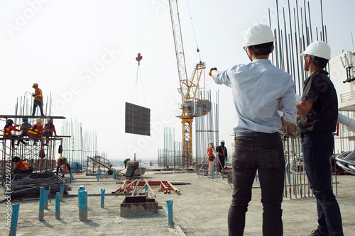 Two engineers work on the construction site. They are checking the progress of the work. photo