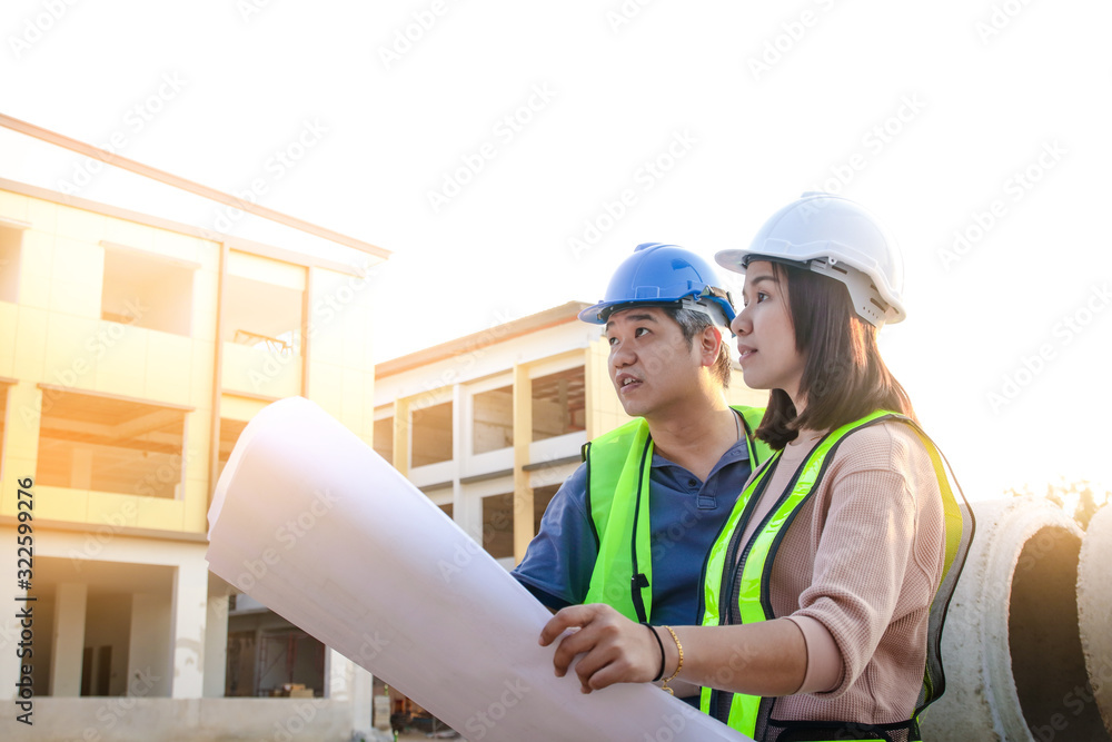 Engineers and architects, men and women, look at the building blueprint to check the accuracy of the construction. Engineers and architects, men and women, look at the building blueprint to check the accuracy of the construction.