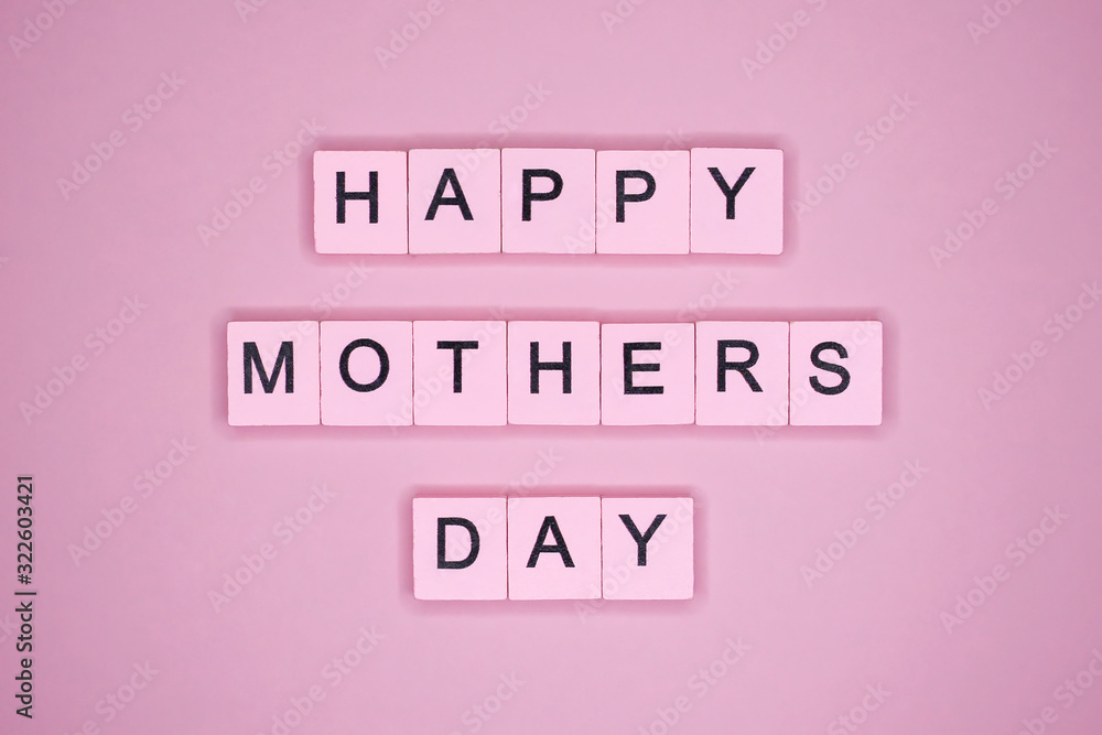 Happy mothers day, words wooden cubes on a pink background