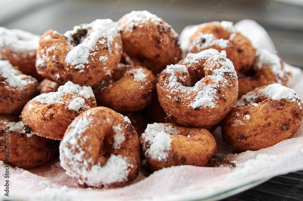 curd rings with topping from powder in a plate on a wooden background curd rings with topping from powder in a plate on a wooden background