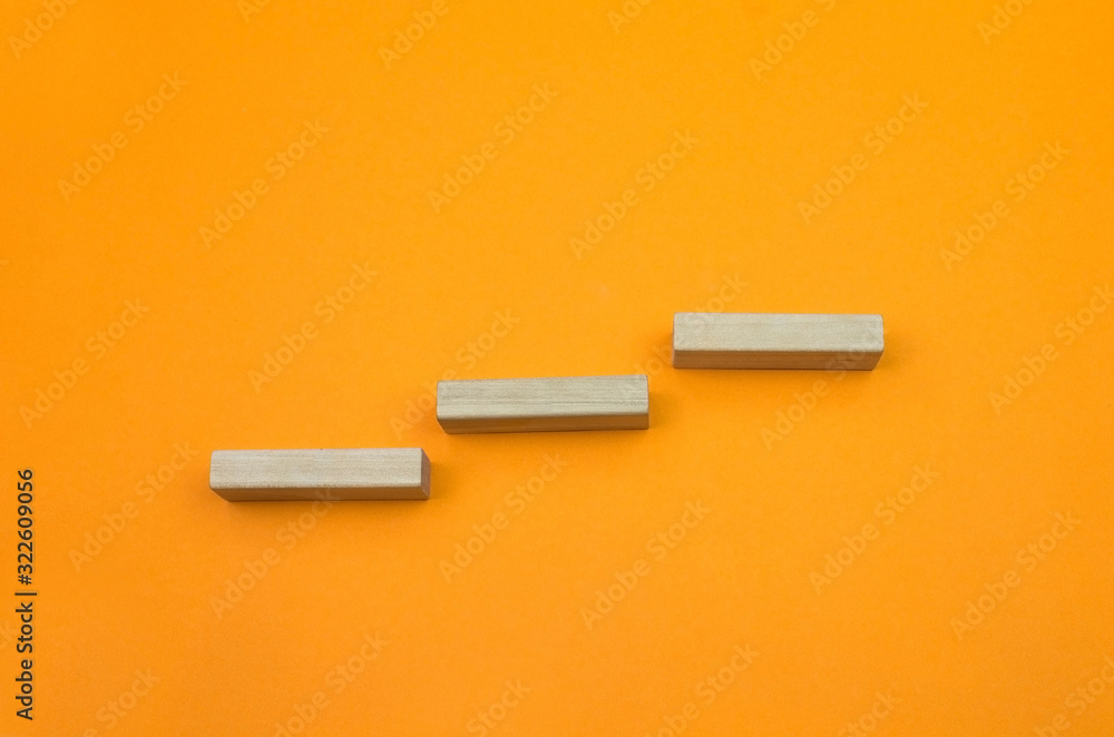 Block woodenn staircase like graph progress success on the gradient orange background Block woodenn staircase like graph progress success on the gradient orange background