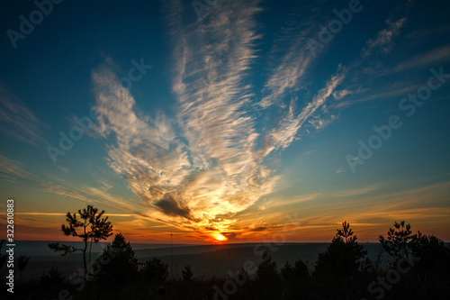 Gorgeous colorful sunset on cloudy blue sky in field and forests  beauty in nature