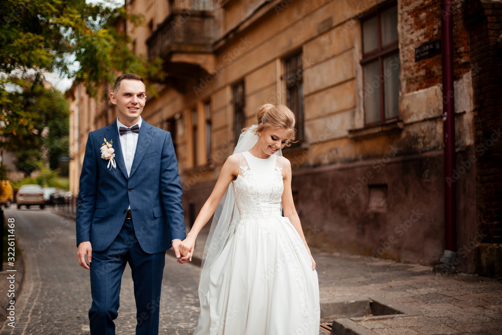 gorgeous wedding couple walking in the old city