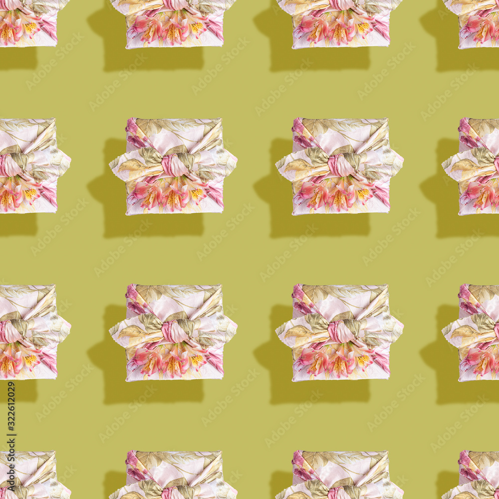 Seamless pattern of gift boxes trendy wrapped in cloth in Furoshiki technique with flowers and shadows on green backdrop. Valentine's day, mother's day, Women's day, Birthday. Zero Waste. Top view. Seamless pattern of gift boxes trendy wrapped in cloth in Furoshiki technique with flowers and shadows on green backdrop. Valentine's day, mother's day, Women's day, Birthday. Zero Waste. Top view.