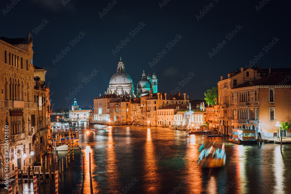 Venice, Italy. Majestic Basilica di Santa Maria della Salute at night. Grand Canal light reflected on water surface.