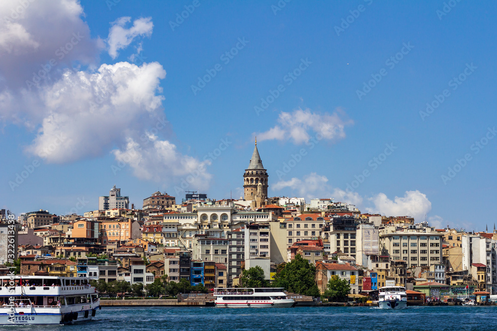 June 18, 2019 - Istanbul, Turkey - View of Galata Tower from the opposite bank on the Golden Horn, ferry boats are in the foreground