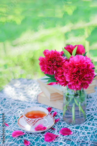 snack in the fresh air. breakfast with a cup of tea in a cozy environment outside. flowers on the table and summer mood