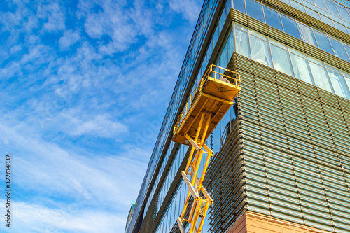 Workers on a Scissor Lift Platform at a construction site. Men at work.