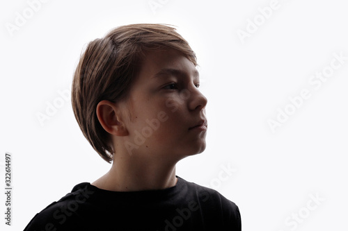 Portrait of teenager on white background. Beautiful young boy in profile. Free space for text.
