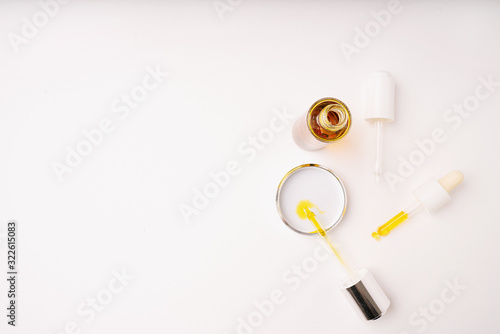 Pipette droppers and opened glass bottle with moisturizing cosmetic oil isolated on a white background. Top view