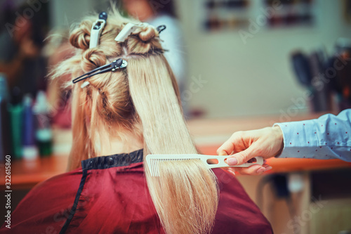 Midsection of male hairdresser drying teenage customer's hair in salon