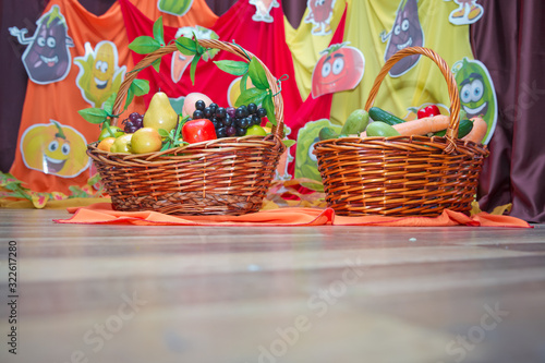 Cucumber  red pepper  carrot  potato  grape in the basket . Basket and artificial fruits on wooden table. Table-still life. The fruits are in the basket.