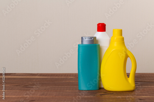 Cleaning product plastic container for house clean on wooden table and gray background . household chemicals