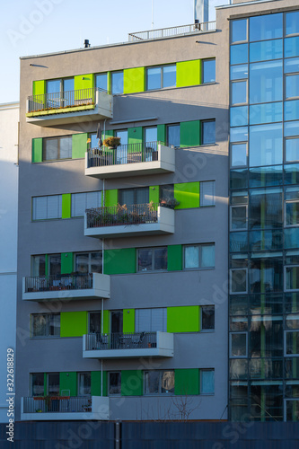 balconies in modern building with a glass front, green and grey facade