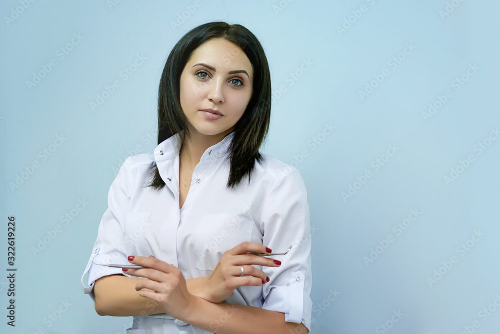 portraits of a woman of Caucasian appearance profession dentist with tools in hands on an isolated blue background, medicine concept portraits of a woman of Caucasian appearance profession dentist with tools in hands on an isolated blue background, medicine concept