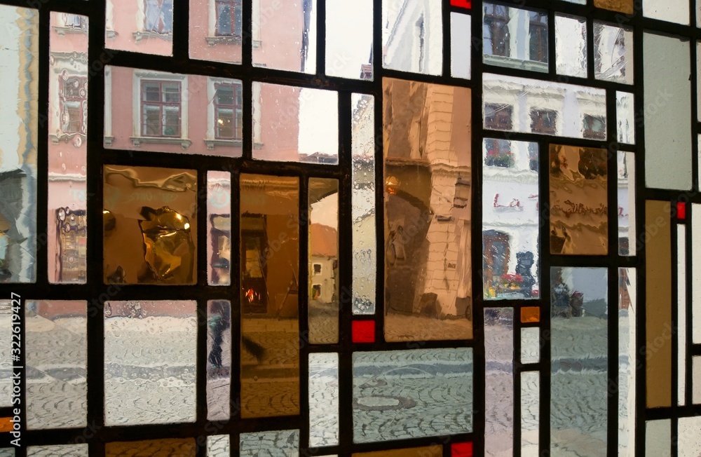 View on the street through the window made of colored oblong panes.