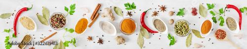 Fototapeta Various assorted colorful spices and herbs on white wooden background top view. Banner size.