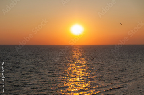 The sunset of the bright summer sun in the sea. © Oleg