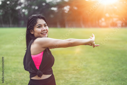 Women perform exercises by focusing on their hands and arms before exercising in the park.