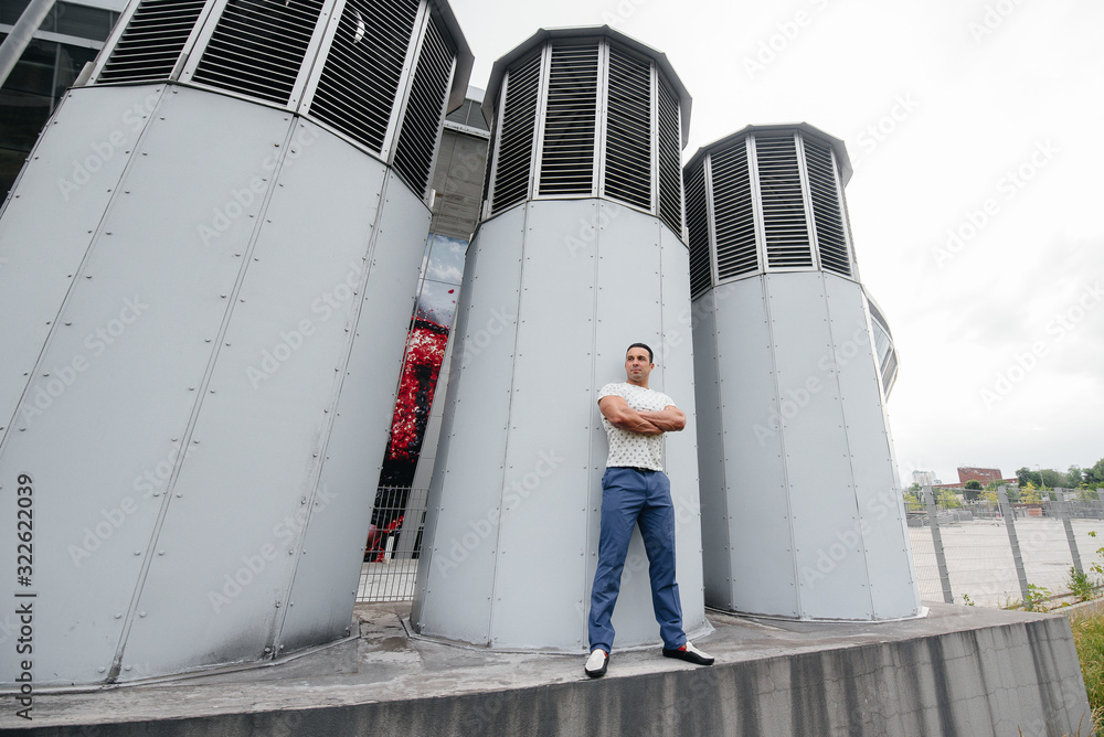 Obraz premium A young man stands in the open air near technical structures