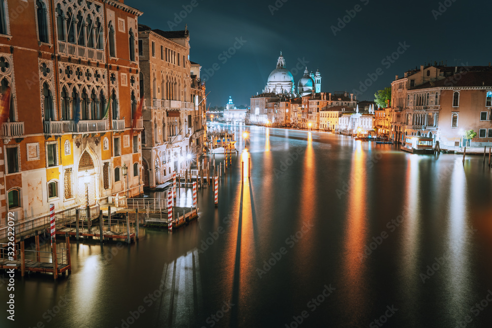 Venice, Italy. Grand Canal at night. Illumination light reflected on water surface. Majestic Basilica di Santa Maria della Salute in background