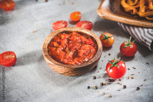 Принти на полотні Tomato sauce with cherry tomatoes on gray table. Traditional dip