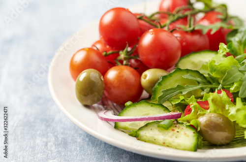 Healthy salad with green olives, cherry tomatoes and rocket. Close up.	