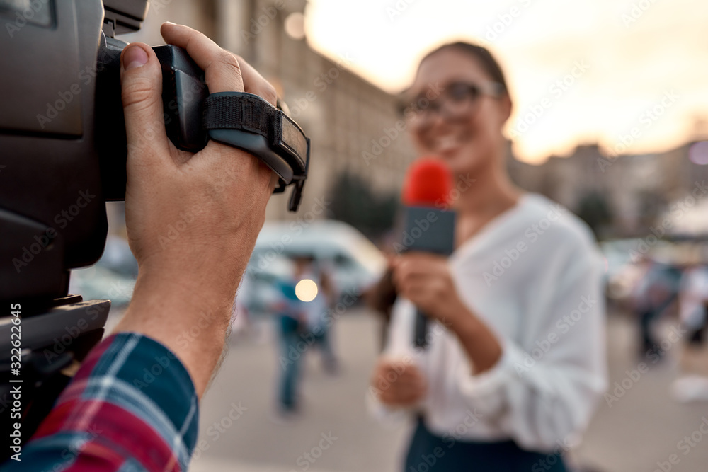 We report to you. TV reporter presenting the news outdoors. Journalism industry, live streaming concept. We report to you. TV reporter presenting the news outdoors. Journalism industry, live streaming concept.